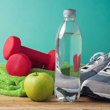 An apple, weights, shoes, water, and a towel